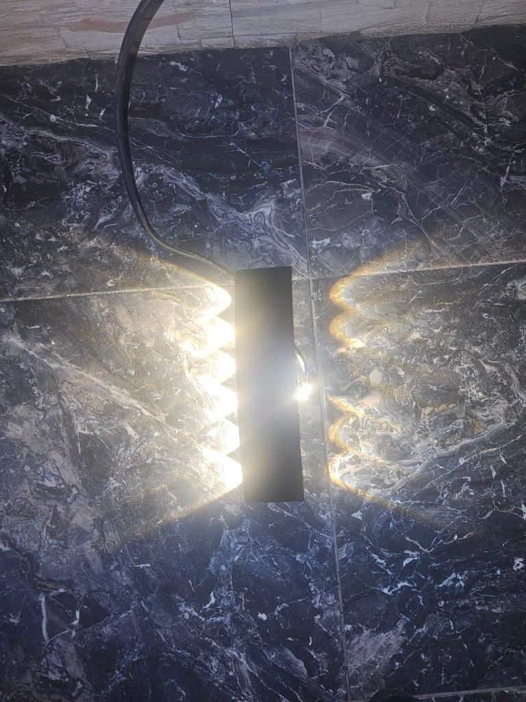 Aplique LED bidireccional instalado, luz cálida sobre mármol